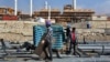 FILE - Construction workers move materials at a gas refinery in Asalouyeh, Iran, on Jan. 22, 2014. The Iranian parliament voted on Nov. 19, 2023, to raise the retirement age for men from 60 to 62.