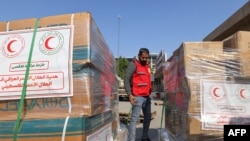 An employee from the Iraqi Red Cresent Society prepares boxes of humanitarian aid bound for Egypt, where it will be distributed to Palestinians in the Gaza Strip, in the organization's headquarters in Baghdad, Nov. 26, 2023.