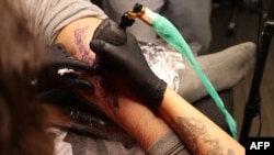 A tattoo artist traces a design on a customer at a tattoo studio in Tehran, Iran, on Nov. 7, 2023.