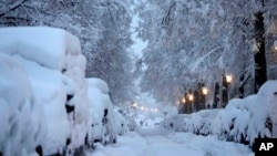 A man walks through snow-covered roads after heavy snow fall in Munich, Germany, Dec. 2, 2023.