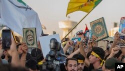 Iraqis raise copies of the Quran, Muslims' holy book, during a protest in Tahrir Square, July 20, 2023 in Baghdad, Iraq. 
