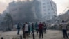 FILE - Journalists observe as Palestinians inspect the rubble of a building after it was struck by an Israeli airstrike, in Gaza City, Oct. 8, 2023.
