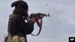 FILE - This image posted March 18, 2019, by the Amaq news agency shows an Islamic State fighter shooting at Syrian Democratic Forces in Baghouz, Syria. IS said on Nov. 10, 2023, that it had attacked pro-government forces in Syria in preceding days.