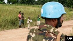 Children look at an United Nations (UN) Bangladeshi soldier part of MINUSCA (United Nations Multidimensional Integrated Stabilization Mission in the Central African Republic) on the road to Koui, Central African Republic, on Sept. 24, 2020.