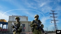 Wanajeshi wa Russia wakiwa wameshika doria nje ya kiwanda cha umeme cha Kakhovka, karibu na mto Dnieper, Kherson, kusini mwa Ukraine. May 20, 2022