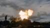 A Ukrainian serviceman reacts as a self-propelled artillery vehicle fires near Bakhmut, Donetsk region, Ukraine, Oct. 22, 2022. 