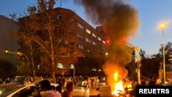 FILE- A police motorcycle burns during a protest over the death of Mahsa Amini, in Tehran, Iran September 19, 2022. 