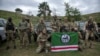Volunteer soldiers pose with a flag of the Chechen Republic of Ichkeria after training near Kyiv, Ukraine, Aug. 27, 2022. Volunteers have signed up to fight on both sides of the conflict.