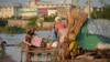 A Pakistani family look for salvageable belongings from their flood-hit home, in Sohbat Pur city of Jaffarabad, a district of Pakistan's southwestern Baluchistan province, Sunday, Aug. 28, 2022.