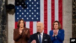 Presidente Joe Biden aplaudido no discurso sobre o Estado da União pela vice-presidente, Kamala Harris, e pela presidente da Câmara dos Representantes, Nancy Pelosi, 1 Março 2022