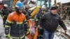 Spasioci evakuišu telo civila poginulog u ruskom raketnom udaru na zgradu u kojoj je živeo, u gradu Zmijiev, u regionu Harkova, Ukrajina, 8. januara 2024.