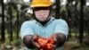 FILE - A worker holds palm oil fruits while posing for a picture at an oil palm plantation in Slim River, Malaysia August 12, 2021. Picture taken August 12, 2021.