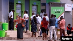 FILE - People queue at ATMs in Abuja, Nigeria, March 30, 2020.
