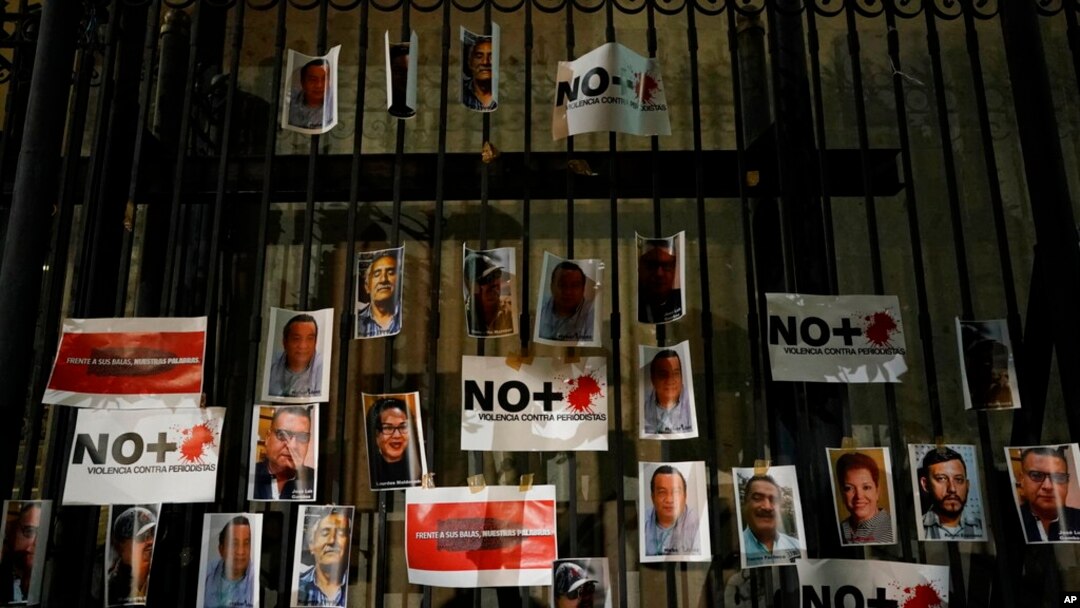 Fotografías de periodistas asesinados se publican en el portón de la oficina del Fiscal General de México durante una vigilia para protestar por el asesinato del periodista Heber López, en la Ciudad de México, el lunes 14 de febrero de 2022.