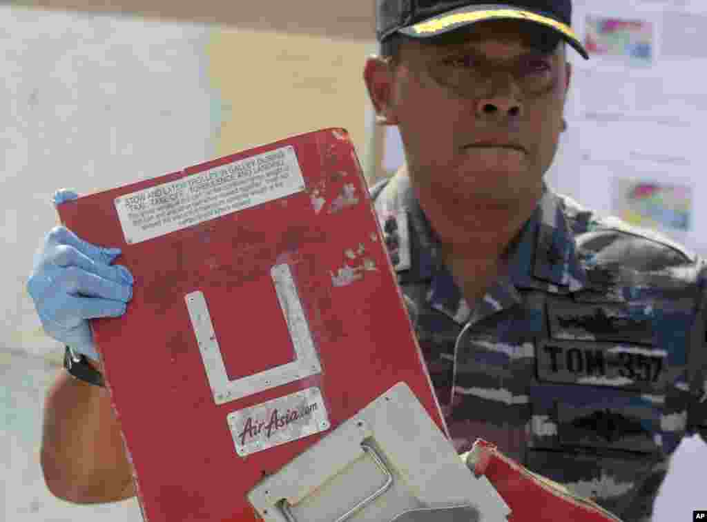 Commander of Indonesian Navy ship KRI Bung Tomo Col. Yayan Sofyan holds a piece of the AirAsia Flight 8501 recovered in search operations for the ill-fated jetliner, during a press conference at the Navy's Eastern Fleet Naval Base in Surabaya, East Java, Indonesia, Jan. 5, 2015.