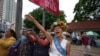 Cambodian-American lawyer Theary Seng, dressed in a pageant costume that reads "Lady Justice", shouts slogans outside Phnom Penh Municipal Court in Phnom Penh, Cambodia, Tuesday, May 3, 2022. 