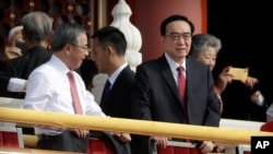 Chen Quanguo, right, Communist Party secretary of China's Xinjiang Uighur Autonomous Region, stands on Tiananmen Gate with other leaders before a parade to commemorate the 70th anniversary of the founding of Communist China in Beijing, Tuesday, Oct…