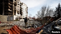 Фото від 7 квітня 2022 року: член команди прокурора з воєнних злочинів поблизу будівлі, що постраждала від обстрілів Росією в Бородянці. REUTERS/Зохра Бенсемра