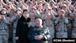 北韓領導人金正恩和女兒與參加北韓新型洲際彈道導彈研製的人員合影（2022年11月27日發表）