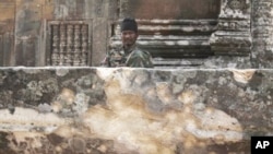 A Cambodian army soldier sits at damaged Cambodia's 11th century Hindu Preah Vihear temple.