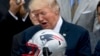 FILE - President Donald Trump is presented with a New England Patriots football helmet by Patriots coach Bill Belichick and Patriots owner Robert Kraft during a ceremony on the South Lawn of the White House in Washington, April 19, 2017.
