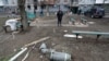 Los restos de un misil se ven en el suelo cerca de un edificio de apartamentos dañado durante el conflicto 