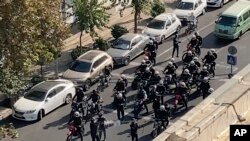 Polisi wa Iran wakiwasili mjini Tehran, Iran, Jumatano kuwatanwanya waandamanaji waliokusanyika kuomboleza siku arubaini tangu kufariki Mahsa Amini. Picha hii imepigwa na mtu ambaye siyo mfanyakazi wa shirika la habari la AP.