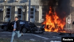 Mtu anakimbia baada ya kombora la Russia kupiga gari mjini Kyiv. Oct. 10 2022
