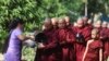 A Buddhist monk receives alms from a devotee as they collect their morning alms Thursday, April 14, 2022, in Yangon, Myanmar. (AP Photo/Thein Zaw)