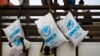 FILE - Workers unload sacks of UNHCR aid supplies at the Al Adala settlement for internally displaced people in Mogadishu,Aug.13, 201.