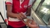 FILE - A driver hands over Myanmar kyats to an attendant as payment for fuel at a gas station in Botahtaung township in Yangon, Myanmar on Nov. 12, 2021.