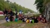 In this photo released by the Malaysia Royal Police, police detain Rohingya refugees who had escaped from the Sungai Bakap Temporary Immigration Depot, Penang, Malaysia, Wednesday, April 20, 2022. (Malaysia Royal Police via AP)