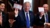 President Donald Trump holds an example of what a new tax form may look like during a meeting on tax policy with Republican lawmakers including House Speaker Paul Ryan of Wis., and Chairman of the House Ways and Means Committee Rep. Kevin Brady, R-Texas, right, in the Cabinet Room of the White House, Thursday, Nov. 2, 2017, in Washington. 