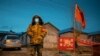 This photo taken on April 21, 2020 shows a staff member keeping watch at a checkpoint in the border city of Suifenhe, in China's northeastern Heilongjiang province. - A cluster of COVID-19 coronavirus cases in China's northeastern city of Harbin has…