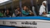 FILE - Cambodian migrant workers sit in a bus upon arrival at Cambodia-Thailand's international border gate in Poipet, Cambodia, from Thailand, Tuesday, June 17, 2014.