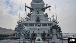 In this photograph taken on Dec. 22, 2023, sailors stand next to anti-submarine indigenous rocket launchers of the stealth guided-missile destroyer INS Imphal ahead of its commissioning into the Indian Navy, at the Naval Dockyard in Mumbai. 