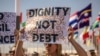 Des militants brandissent des pancartes lors d'une manifestation contre la pauvreté et le changement climatique au premier jour des réunions annuelles du Fonds monétaire international et du Groupe de la Banque mondiale, à Marrakech, le 9 octobre 2023.