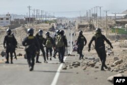 Polisi berpatroli di jalan raya Pan-Amerika di La Joya ketika para demonstran melakukan blokade untuk menuntut pengunduran diri Presiden Peru Dina Boluarte di Arequipa, Peru, 12 Januari 2023. (Foto: AFP)