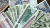 FILE - Myanmar and U.S. banknotes are pictured on Aug. 18, 2011 in Yangon, Myanmar. Foreign business groups in Myanmar have raised concerns about new rules requiring businesses and individuals to convert all foreign currency holdings into the local curren