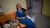 FILE - Nurse Marie-Laure Satta rests during her New Year's Eve shift in the COVID-19 intensive care unit at the la Timone hospital in Marseille, southern France, Dec. 31, 2021.