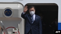South Korean President Moon Jae-in waves from the steps of his plane as he leaves for the United States at Seoul Air Base in Seongnam, south of Seoul, on May 19, 2021. 