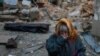 A woman reacts next to the body of her neighbor found under debris of a residential house destroyed by a Russian missile attack in Mykolaiv, Ukraine.