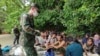 In this photo released by the Royal Thai Navy taken June 4, 2022, members of the Thai navy help Rohingya refugees found on Koh Dong Island in Satun province, southern Thailand.