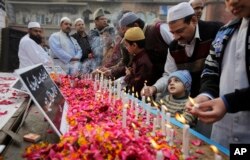 FILE - Indian Muslims pay tribute to Indian soldiers killed in the recent Pathankot air base attack, outside a mosque in New Delhi, India, Jan. 8, 2016.