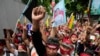 Myanmar nationals living in Thailand with a picture of deposed Myanmar leader Aung San Suu Kyi, seen at center, stage a rally outside Myanmar's embassy in Bangkok, Thailand, July 26, 2022.
