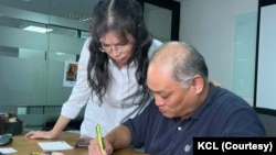 曾遭中國監禁的台灣籍人權工作者李明哲與妻子李淨瑜在位於台北的國際特赦組織寫信聲援人權受害者。(美國之音記者金谷攝)