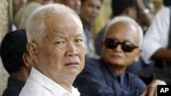 Former Khmer Rouge leaders Khieu Samphan, left, and Nuon Chea, right, look on during the funeral for Khieu Ponnary, the first wife of Khmer Rouge leader Pol Pot, in 2003, file photo. 