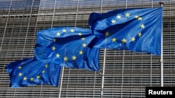 FILE -European Union flags flutter outside the EU Commission headquarters in Brussels, Belgium, June 17, 2022.