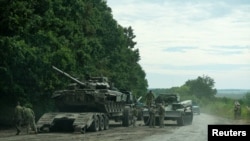 Українські військові готуються транспортувати російський танк, захоплений під час контрнаступальної операції у Харківській області восени 2022 року.