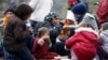 FILE - Migrants rest before crossing the Austrian-German border in Achleiten, Austria, across from Passau, Germany, Oct. 29, 2015.